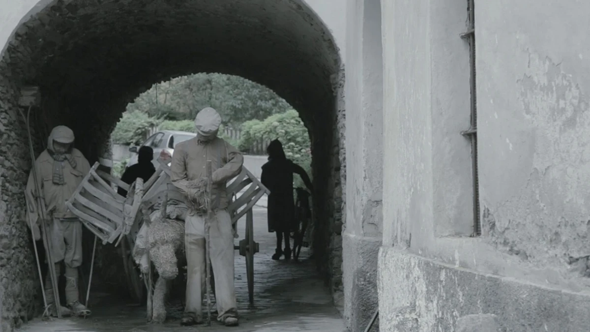 Workers transporting materials through an archway, highlighting the filming process in construction project documentation.